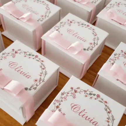 Caixinhas brancas de lembrança com coroa de flores e laço rosa